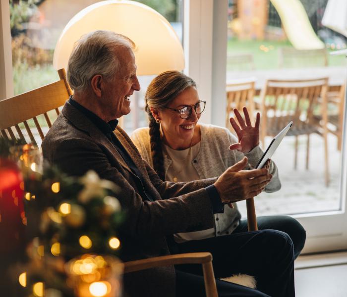 Senior en thuishulp bij de kerstboom